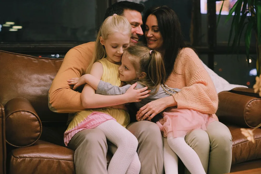 Familia abrazada en el sofá